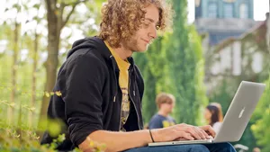 Student des Bachelorstudiengangs Agrarwissenschaften und Gartenbauwissenschaften an der TUM School of Life Science draußen am Laptop