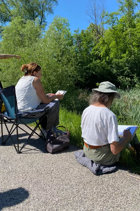 Participants in nature journaling by the pond.