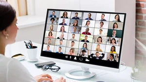 Eine Mutter nimmt an einem Elterninfoabend per Zoom teil.