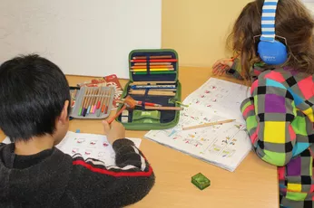 Kinder beim Hausaufgaben machen im TUM Kinderhort Freising