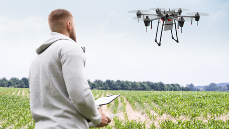 Researcher pilots a drone to collect data in an experimental field Researcher pilots a drone to collect data in an experimental field