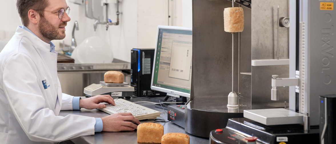 Master student measuring gluten-free breads at the laser volumeter